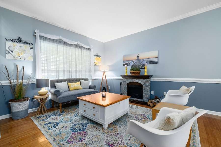 Salon lumineux et accueillant aménagé pour une location meublée avec cheminée.