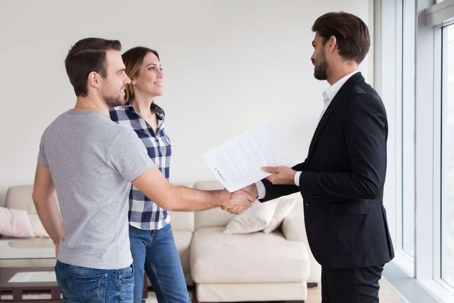 Un agent immobilier valide le dossier du locataire idéal lors de la signature d'un bail.